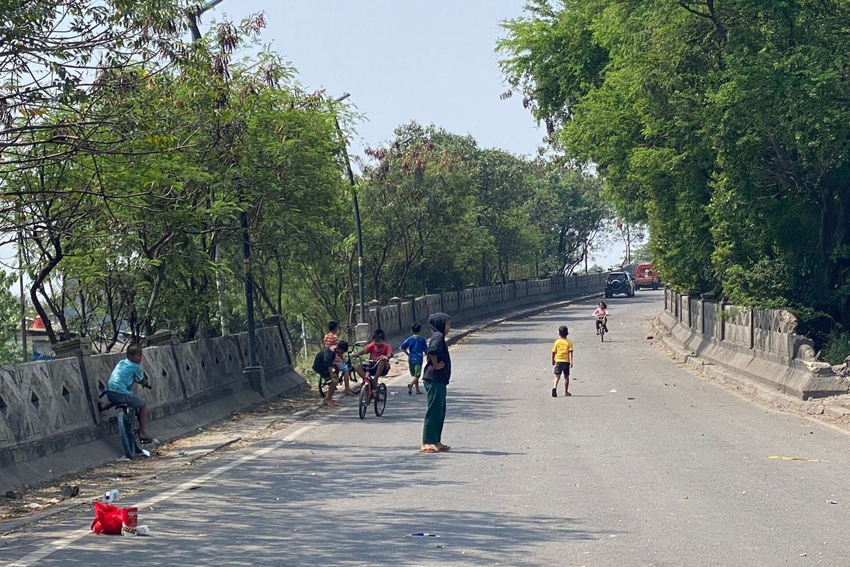 Bocah tengah bersepeda di jembatan Jalan Akses Marunda. Jalanan ini ditutup sementara karena dalam proses pebaikan.