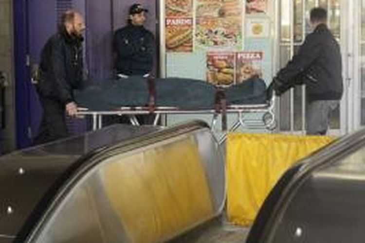 Sejumlah petugas memindahkan jenazah Naima Rharouity, seorang perempuan berusia 47 tahun, setelah hijabnya dan rambutnya tersangkut di sebuah esklator di stasiun kereta bawah tanah Montreal, Kanada