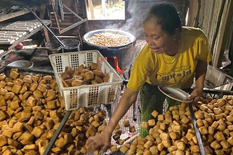 Sri, pengusaha tahu di kawasan Tanjung Piayu, Batam, Kepri tengah menggoreng tahu di rumah produksi miliknya. Saat ini kenaikan harga kedelai membuatnya dan sejumlah pengusaha serta pedagang tahu dan tempe resah.