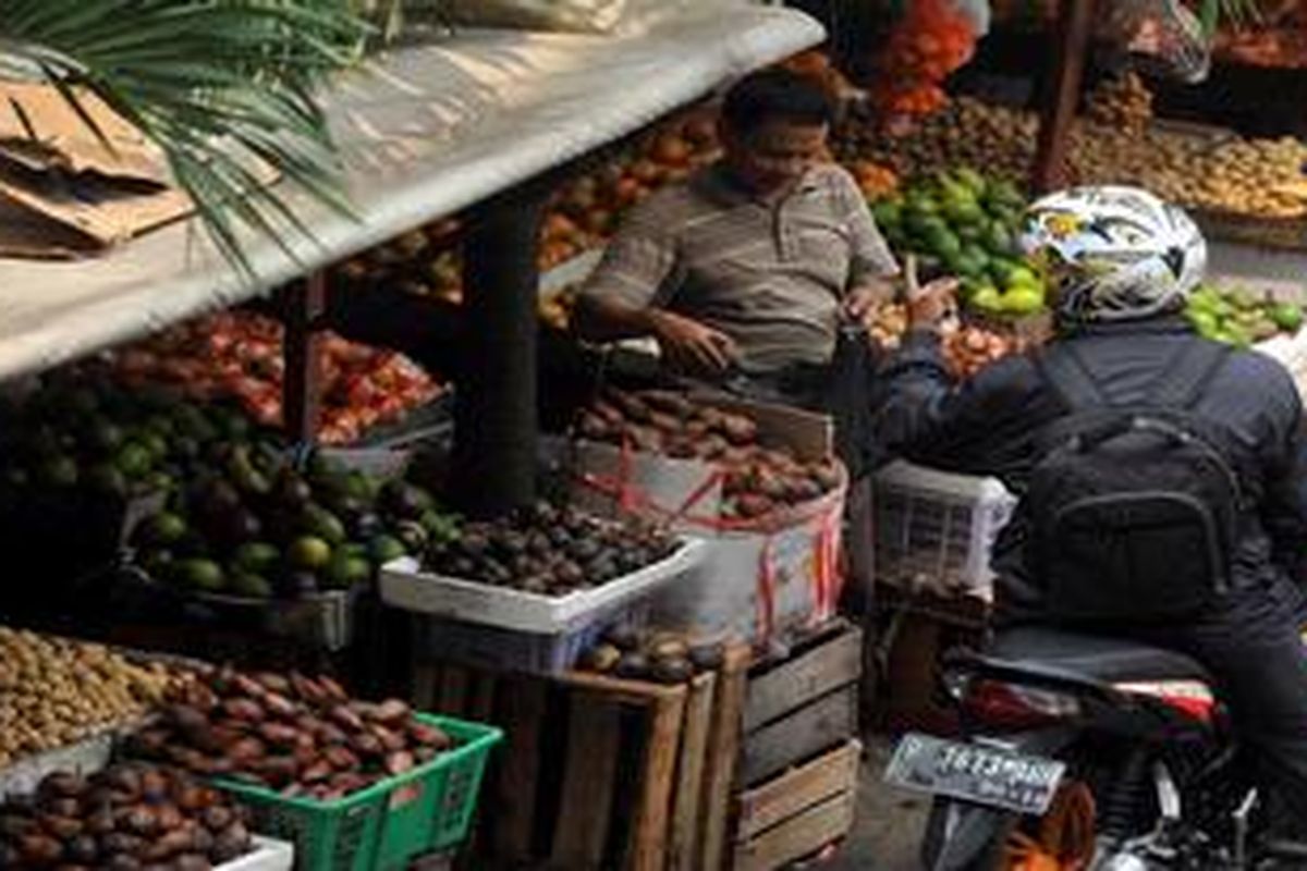 Pedagang buah melayani pembeli di Jakarta. 