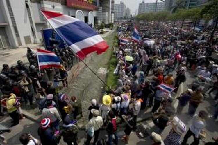 Ribuan pengunjuk rasa mengepung kantor sementara PM Yingluck Shinawatra dan menuntut agar sang perdana menteri mengundurkan diri.