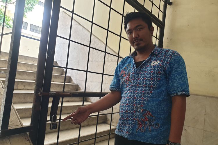 Matheus Situmorang, mahasiswa Pascasarjana Magister Ilmu Hukum, menunjukkan pintu besi akses menuju ruang kelas Fakultas Hukum digembok di Universitas Dharma Agung, Kota Medan pada Kamis (6/3/2025).