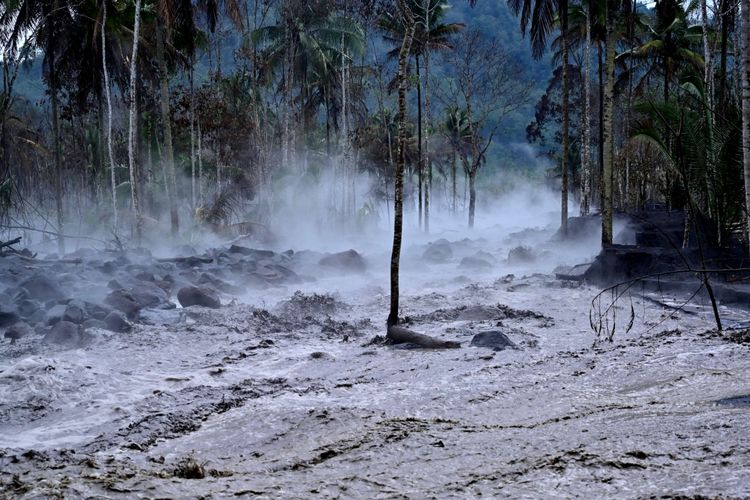 Kepulan asap menyelimuti area yang terendam banjir lahar hujan Gunung Semeru di Dusun Kamar Kajang, Candipuro, Lumajang, Jawa Timur, Kamis (16/12/2021). Erupsi Gunung Semeru pada Kamis pukul 09.01 WIB yang disusul hujan deras di daerah itu mengakibatkan banjir lahar hujan menerjang beberapa tempat di wilayah hilir.