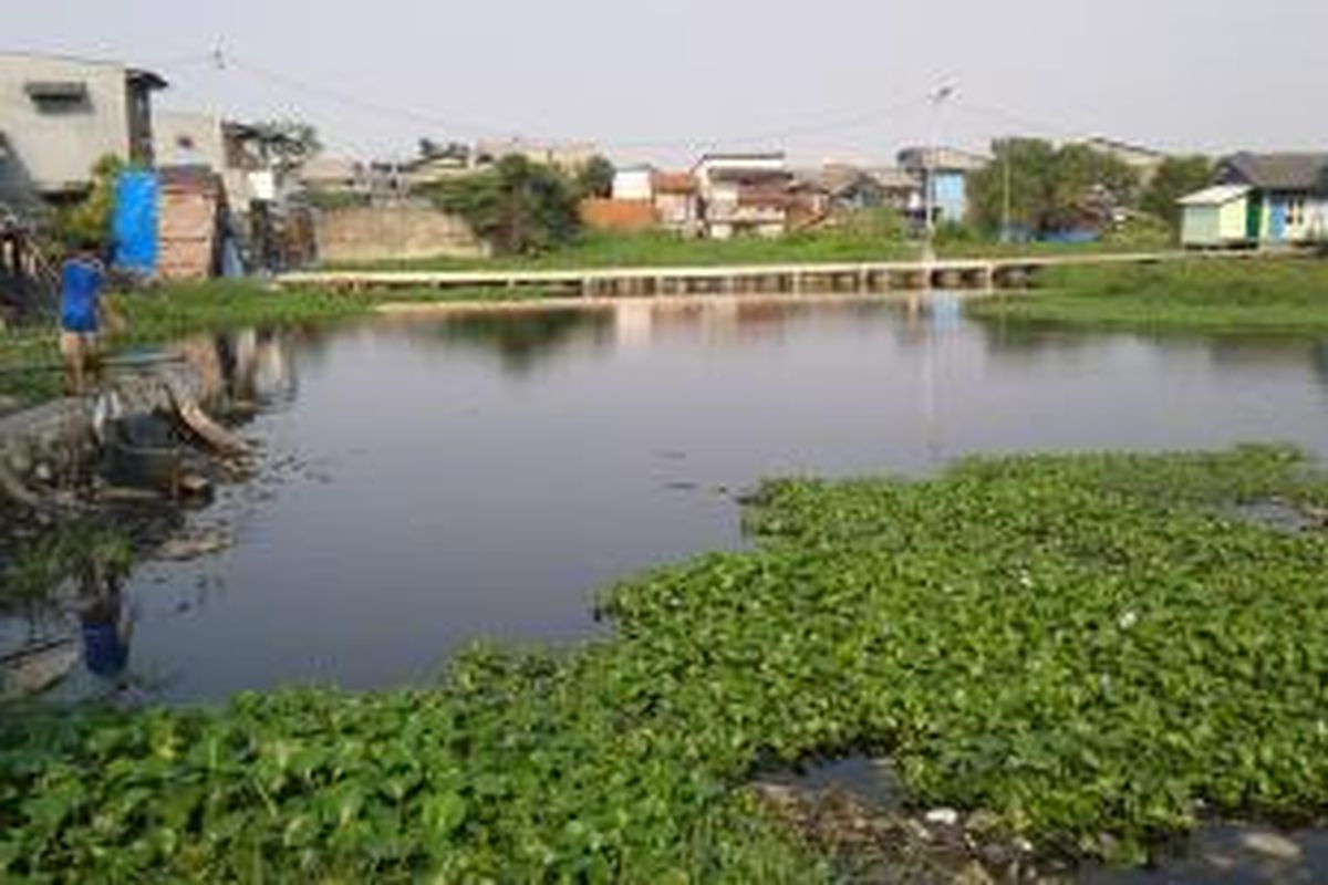 Seorang warga memanfaatkan area Makam Kapuk Teko, Kampung Apung, Cengkareng, Jakarta Barat, yang digenangi air sebagai tempat memancing ikan, Kamis (31/7/2014).