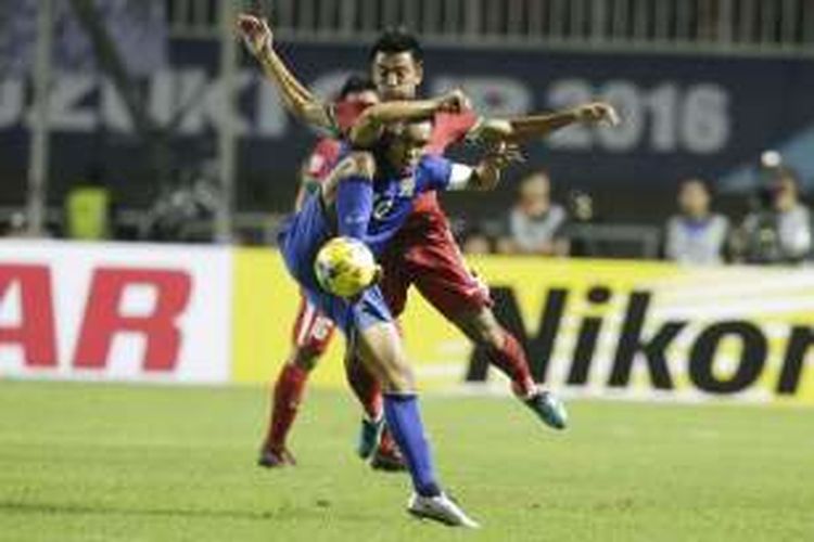 Pemain Thailand Teerasil Dangda, berebut bola dengan pemain Indonesia Bayu Pradana Andriatmoko, dalam laga final Piala AFF 2016 di Stadion Pakansari, Bogor, Rabu (14/12/2016). Indonesia meraih kemenangan 2-1 atas Thailand. AP PHOTO / ACHMAD IBRAHIM