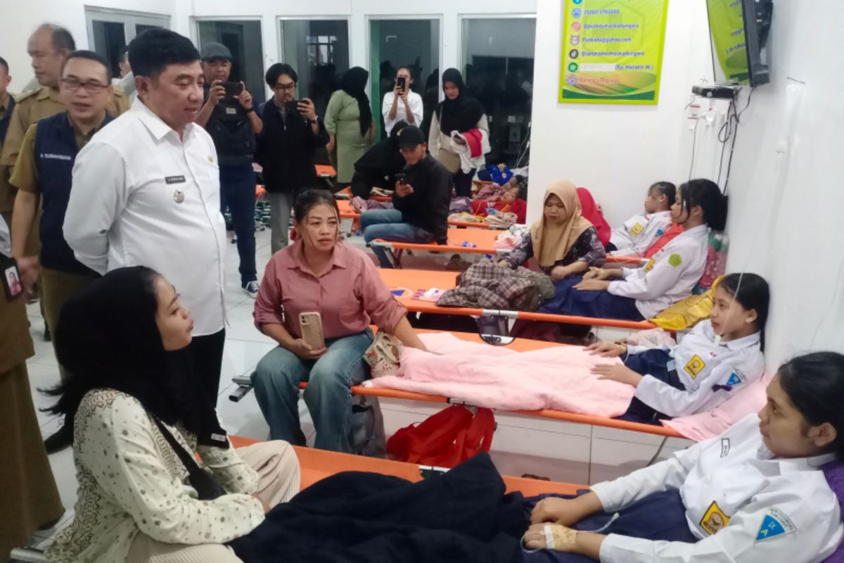 Bupati Garut Abdusy Syakur Amien (baju putih) berdialog dengan siswa yang jadi korban keracunan MBG di Puskesmas Kadungora, Selasa (30/09/2025) malam
