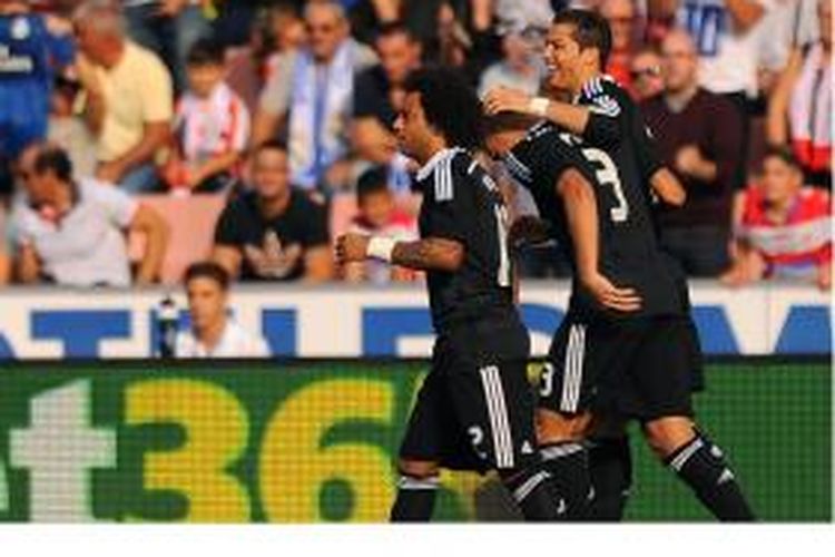 Penyerang Real Madrid, Cristiano Ronaldo (kanan), mendapat sambutan dari Marcelo (kiri), setelah dia mencetak gol ke gawang Granada dalam laga Primera Division di Nuevo Los Carmenes, Sabtu (1/11/2014).
