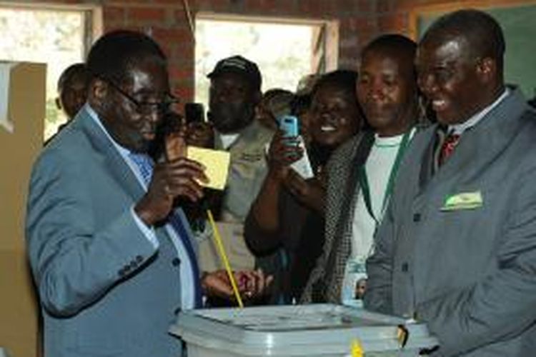 Presiden Zimbabwe Robert Mugabe memberikan suara dalam pemilihan umum negeri itu disaksikan pejabat komisi pemilihan umum dan sejumlah rakyat Zimbabwe.