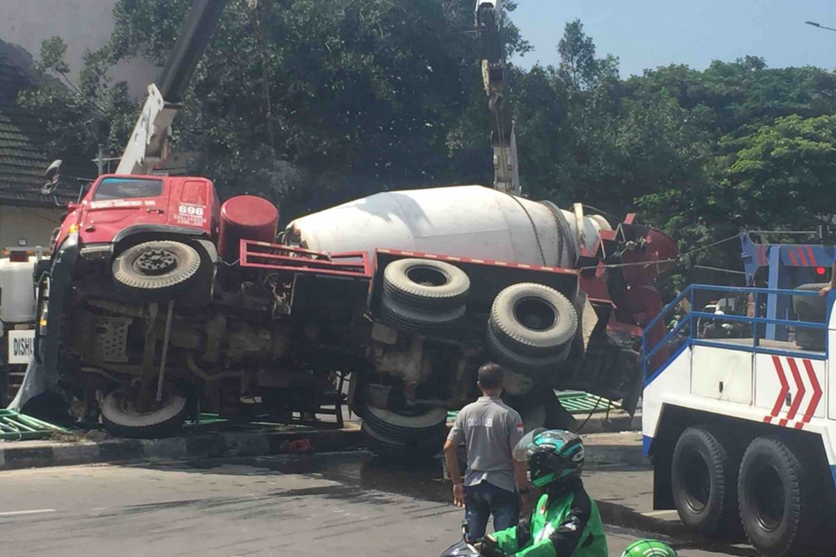 Sebuah truk molen terguling di ruas Jalan Jatibaru, Jakarta Pusat, Jumat (13/4/2018). Tiga mobil derek dari Dinas Perhubungan DKI Jakarta pun dikerahkan untuk memindahkan truk tersebut.
