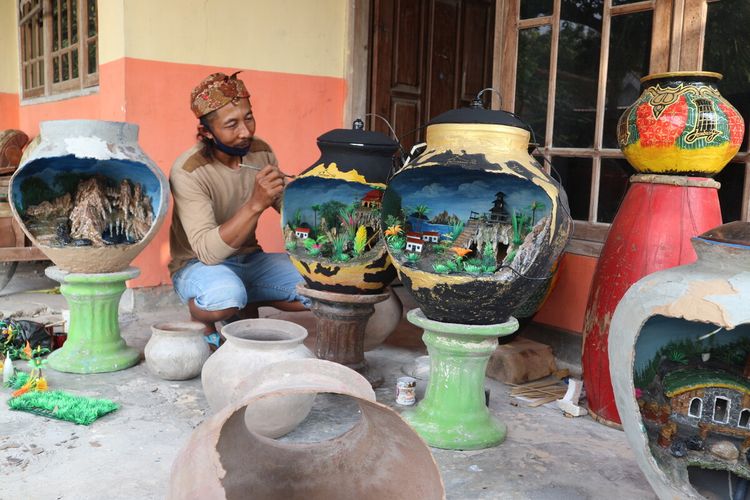 Warga Desa Ngusikan, Kabupaten Jombang, Jawa Timur, Kariyono alias Ari Kodel (49), saat membuat miniatur destinasi wisata alam dari gentong bekas, Jumat (10/7/2020).