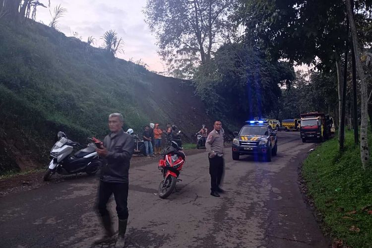 Sejumlah petugas dan warga tengah membersihkan material longsor yang sempat menutup akses Jalan Raya Pangalengan, Kabupaten Bandung, Jawa Barat, Senin (14/4/2025) pagi tadi