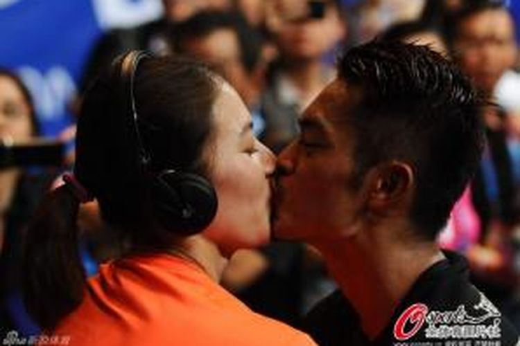 Pebulu tangkis nomor tunggal putra China, Lin Dan (kanan), mencium istrinya, Xie Xingfang, usai memenangkan pertandingan final melawan Lee Chong Wei (Malaysia) pada BWF World Championships 2013 di Tian-He Indoor Gymnasium, Guangzhou, China, Minggu (11/8/2013).