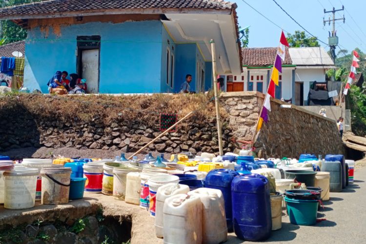 Puluhan wadah penampung air di simpan di pinggir jalan menunggu kedatangan truk tangki pengangkut air bersih di Kampung Siderang Satar Desa Cintanagara, Kamis (10/08/2023)