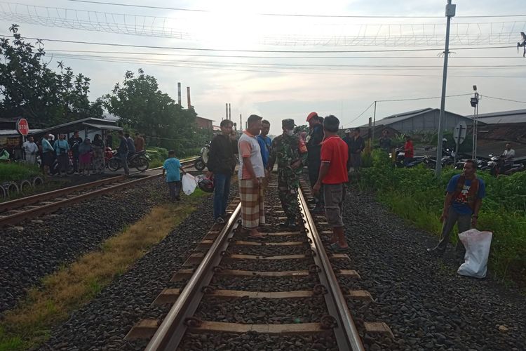 Para petugas dibantu warga mengumpulkan potongan tubuh yang tercecer di rel kereta api Desa Kembangarum, Kecamatan Mranggen, Kabupaten Demak. (dok. Babinsa Kodim Demak)