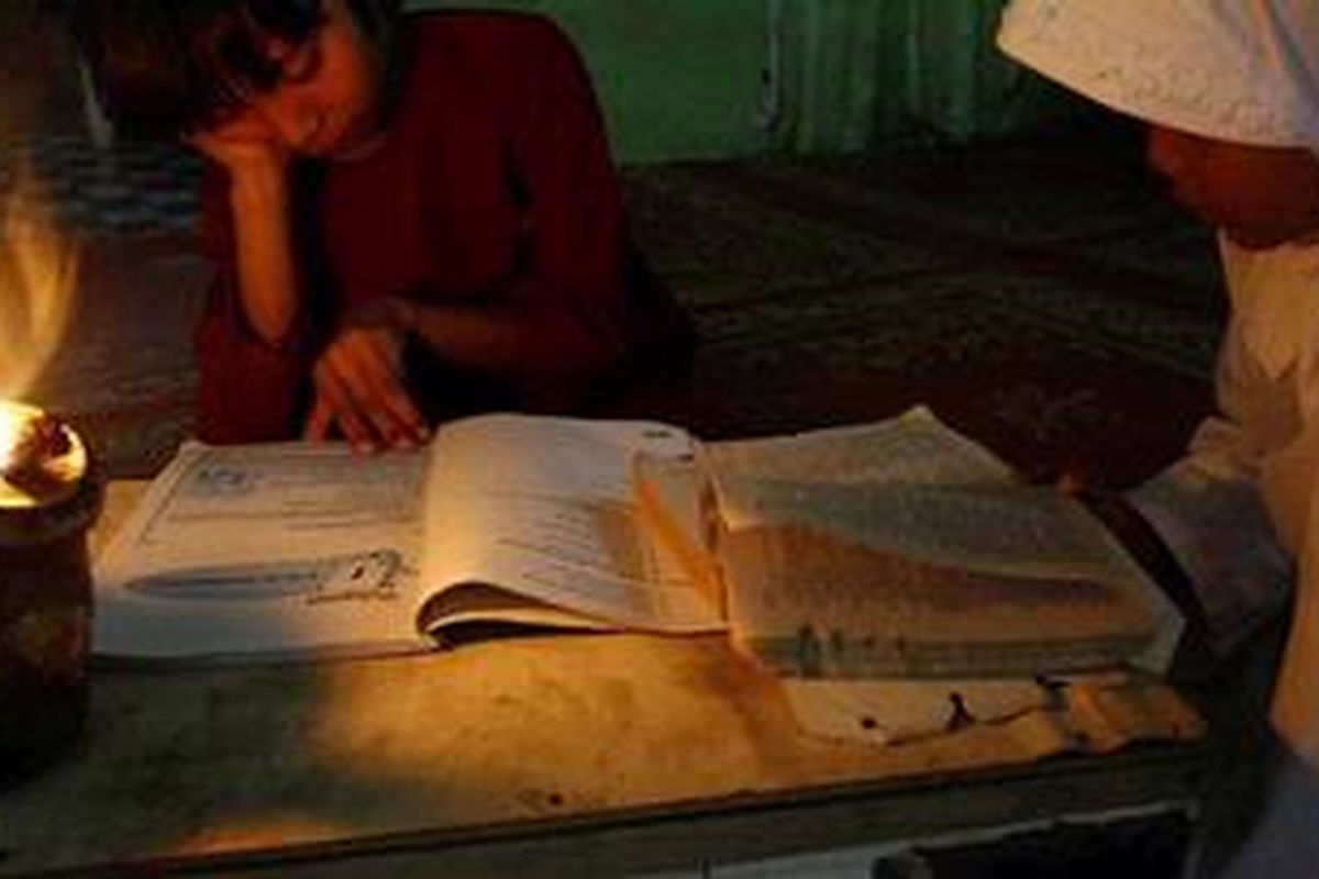 Okura Belum Dialiri Listrik Belajar - Robiati (10) dan Siti (8), dua siswa sekolah dasar ini terpaksa belajar dengan hanya diterangi oleh lampu colok akibat desa mereka yang belum dialiri oleh listrik di jalan Raja Panjang, kelurahan Tebing Tinggi Okura, kecamatan Rumbai Pesisir Pekanbaru, Senin (9/2/2010). Sudah lebih dari puluhan tahun, kawasan tersebut belum juga dialiri listrik oleh pemerintah kota Pekanbaru. Beberapa warga di sekitar kawasan itu terpaksa menggunakan genset secara bersama dengan mebayar iuran Rp 150 ribu perbulannya untuk satu rumah. 