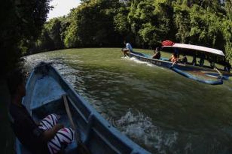 Wisatawan menggunakan perahu mengunjungi obyek wisata Green Canyon, Cijulang, Pangandaran, Jawa Barat, Sabtu (4/5/2013). Obyek wisata ini menawarkan keindahan dinding bebatuan yang ditutupi lumut dan wisatawan dapan menikmatinya dengan menyusuri sungai menggunakan perahu.