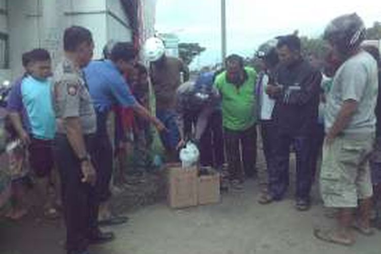 Warga melihat potongan telapak kaki di dalam kardus yang ditemukan di sekitar jalur Pantura di Desa Siwalan, Sragi, Pekalongan.