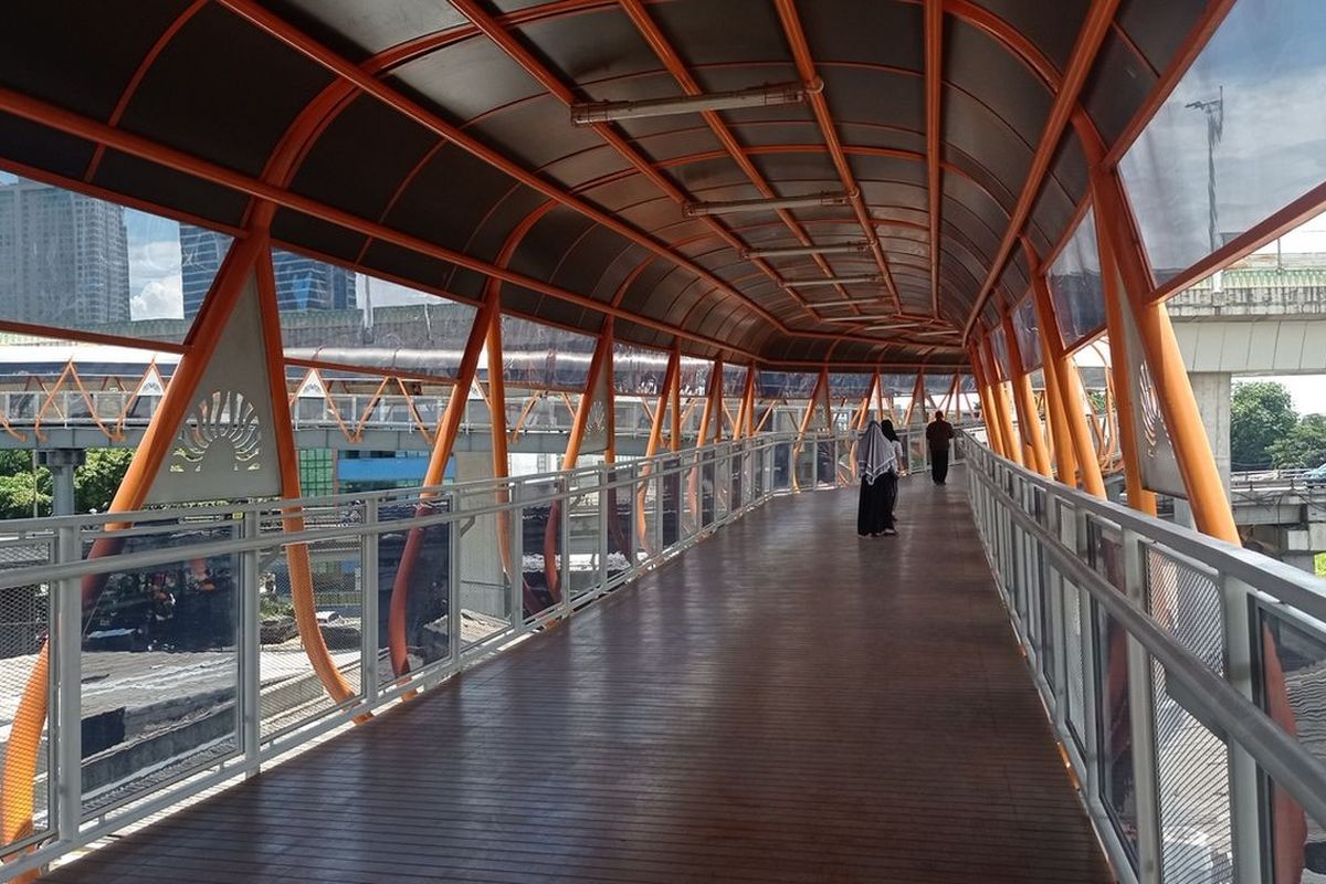 Pengguna angkutan umum berpindah moda melalui Skywalk Kebayoran, Jakarta, Minggu (22/1/2023). Skywalk sepanjang 500 meter ini menghubungkan stasiun dan halte.