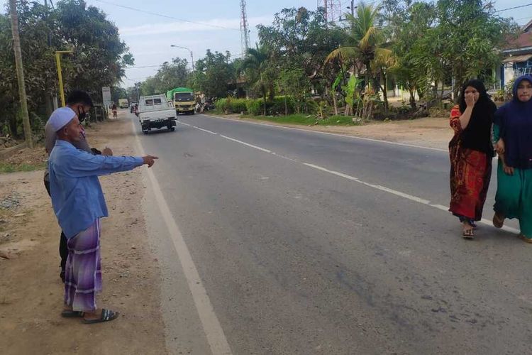 Salah seorang warga menujukkan lokasi terjadinya kecelakaan. 