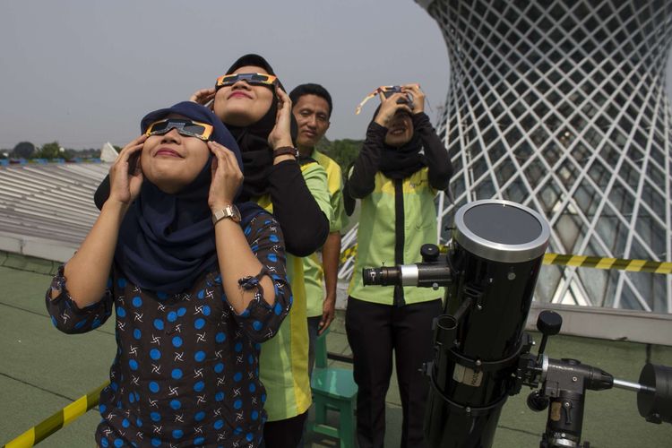 Antusias masyarakat mengamati gerhana matahari cincin di Pusat Peragaan Iptek Kementerian Riset dan Teknologi (PP-IPTEK), Taman Mini Indonesia, Jakarta Timur, Kamis  (26/12/2019). Selama pengataman GMC di PP-IPTEK pengunjung bisa mengamati menggunakan teleskop dan dipadu langsung oleh pemandu.