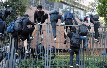 Pengunjuk rasa melompat ke dalam Universitas Politeknik Hong Kong (PolyU) saat gagal meninggalkan tempat setelah terkena gas airmata oleh polisi pada bentrokan di Hong Kong, China, Senin (18/11/2019).