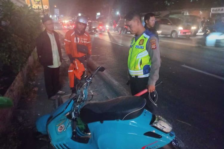 Petugas kepolisian btengag mengevakuasi jenazah AF (22) pengendara motor yang meninggal dunia akibat kecelakaan di Jalan Raya Cinunuk, Kabupaten Bandung, Kamis (19/6/2024)