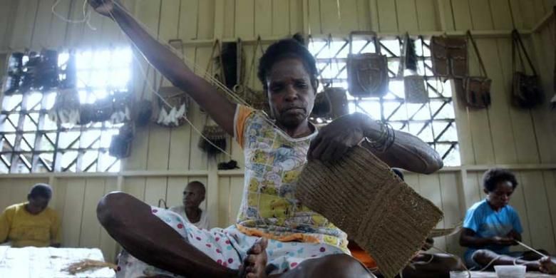 Warga menyelesaikan pembuatan noken (tas dari Papua) dari tali sagu di Sanggar Kelompok Gescu Cepes, Kampung Jasiw, Distrik Atsy, Kabupaten Asmat, Papua, Minggu (18/8/2013). Hasil kerajinan anyaman khas Asmat itu dijual Rp 500.000 per tas.  