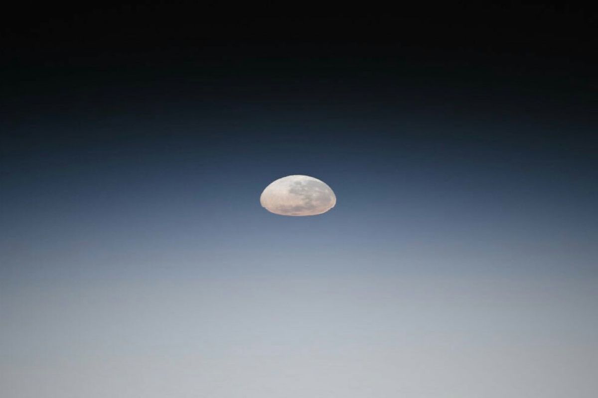 Bulan purnama tampak setengah gepeng diabadikan dari cakrawala stasiun antariksa internasional ISS pada Mei 2019. Efek gepeng ini merupakan implikasi sifat optis lapisan-lapisan atmosfer Bumi yang membiaskan cahaya Bulan. Sifat optis yang sama bertanggung jawab atas munculnya cahaya fajar setiap hari, menjadi penentu waktu subuh.