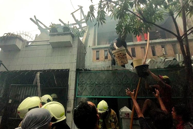 Warga gotong-royong memadamkan api saat kebakaran 5 bangunan rumah di Gang FF, Tanah Sereal, Kecamatan Tambora, Jakarta Barat, Kamis (27/10/2022).