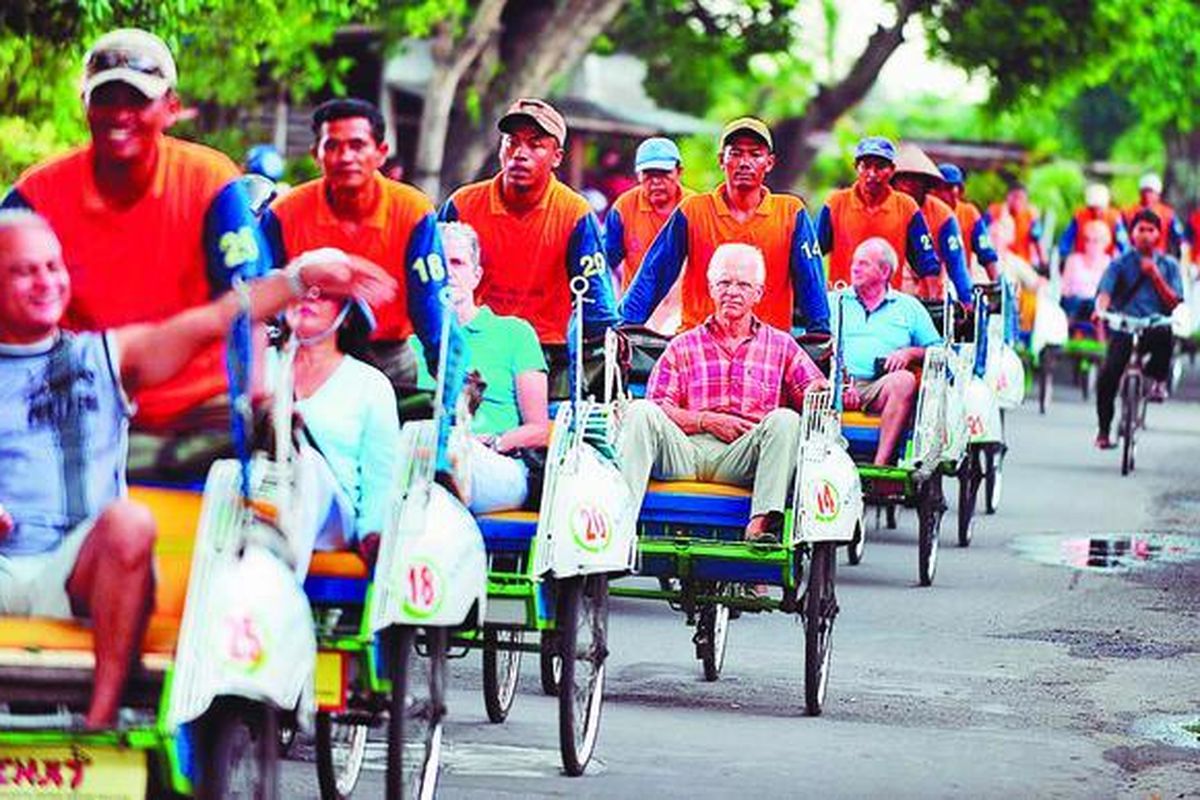 Puluhan wisatawan mancanegara melintas di Jalan Kompol Suprapto, Yogyakarta, saat berkeliling kota menggunakan becak. Kekayaan budaya Kota Yogyakarta tetap menjadi daya tarik wisatawan mancanegara.