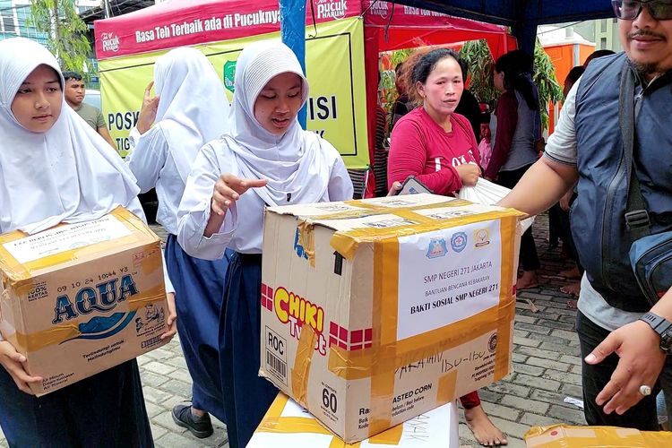Siswa dan siswi SMP 27 Jakarta menyalurkan bantuan pakaian layak pakai dan bahan pokok ke posko pengungsian korban kebakaran di Sukabume Selatan, Kebon Jeruk, Senin (31/10/2022).
