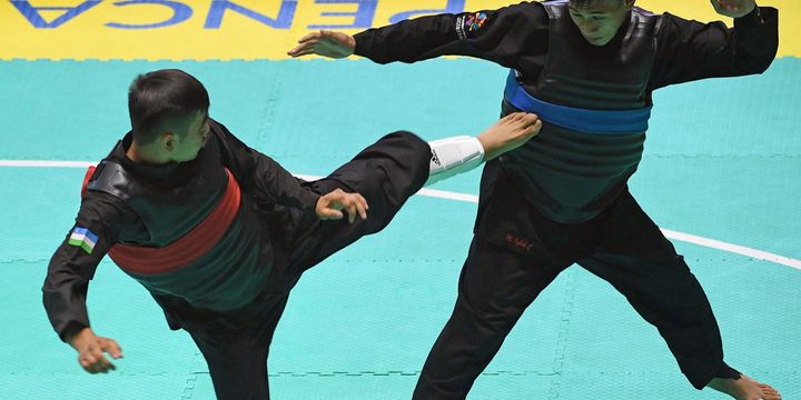 Pesilat Indonesia Iqbal Chandra Pratama (kanan) menghindari tendangan pesilat Uzbekistan Abdumalik Salimov (kiri) dalam laga semifinal Kelas D Putra Asian Games 2018 di Padepokan Pencak Silat Taman Mini Indonesia Indah (TMII), Jakarta, Minggu (26/8). 