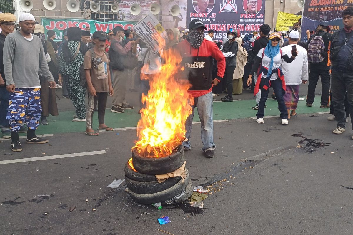 Sejumlah orang yang tergabung dalam aksi penuntutat hak angket dan pemakzulan Presiden Joko Widodo mulai membakar ban di depan gedung DPR/MPR RI, Gelora, Tanah Abang, Jakarta Pusat, Jumat (8/3/2024). 