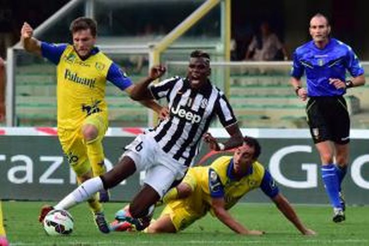 Gelandang Juventus, Paul Pogba (tengah), mencoba menggiring bola melewati pemain-pemain Chievo Verona, pada laga Serie-A, di Marc'Antonio Bentegodi, Sabtu (30/8/2014). 