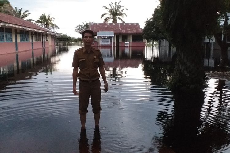 Kasi PMD Kecamatan Bonai Darussalam, M Yamin meninjau sekolah yang digenangi banjir di Desa Bonai, Kecamatan Bonai Darussalam, Kabupaten Rohul, Riau, Senin (2/12/2019).