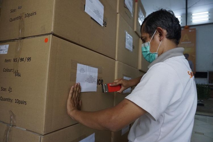 Seorang petugas tengah mempersiapkan bantuan APD yang akan dikirimkan ke rumah sakit di Indonesia.