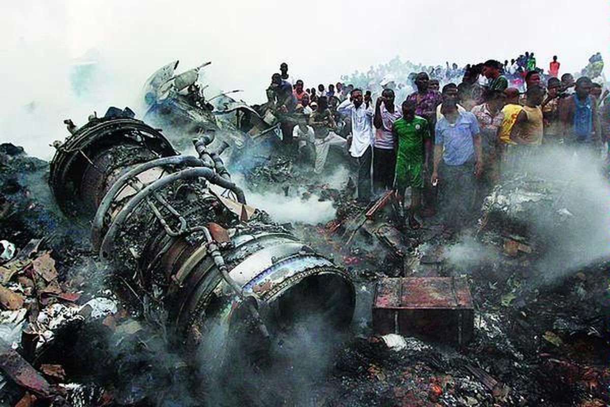 Warga mengerumuni  reruntuhan pesawat yang terjatuh di Lagos, Nigeria, Minggu (3/6). Pesawat penumpang milik maskapai Dana Air yang mengangkut 153 penumpang dan awak itu terjatuh sebelum mendarat di bandara Lagos, Minggu petang. Otoritas setempat mengatakan, semua penumpang dan awak pesawat tewas, begitu juga belasan orang di dalam bangunan yang tertabrak pesawat tersebut. 