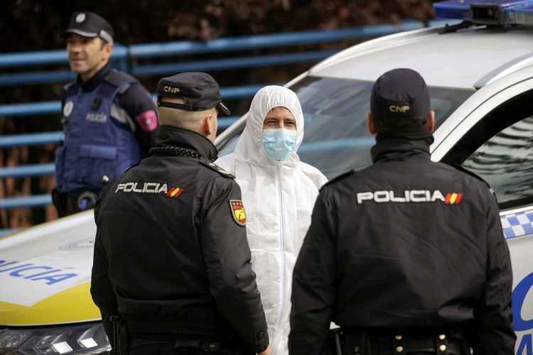 Seorang anggota dari militer Spanyol berbicara dengan dua polisi di Madrid, pada 24 Maret 2020, di tengah wabah virus corona.