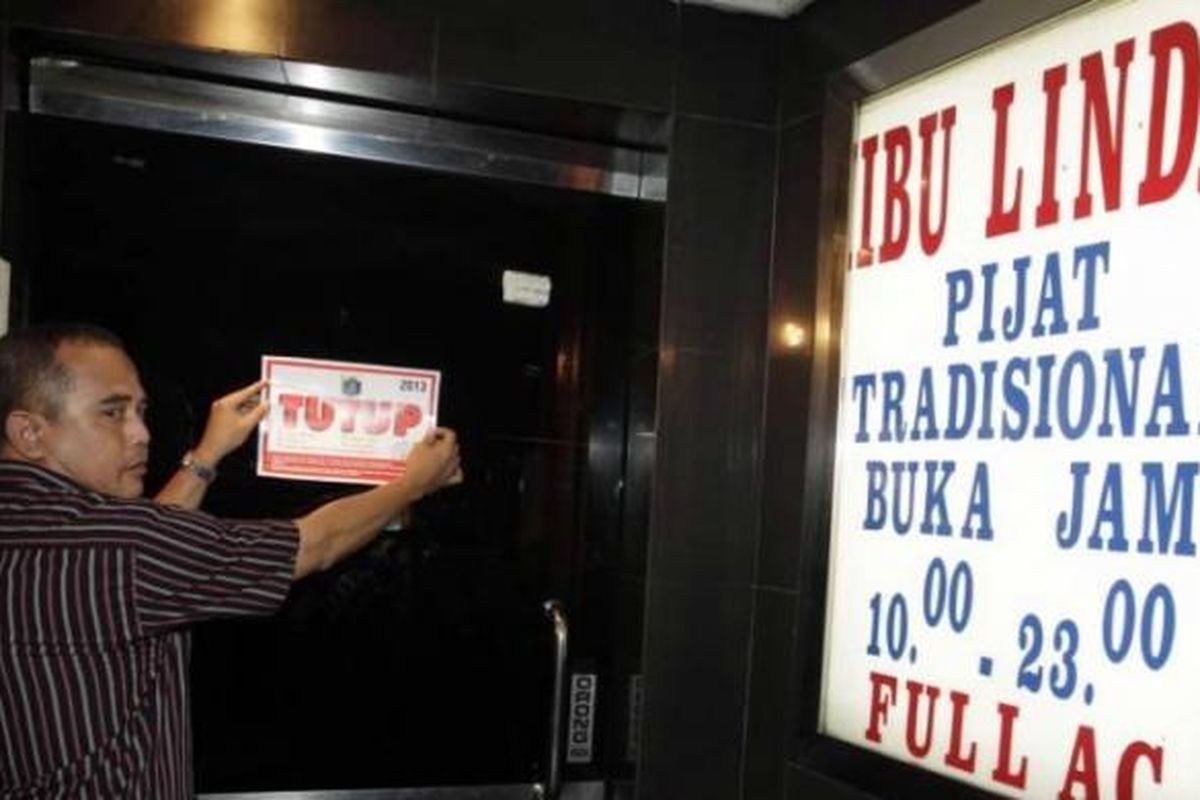 Petugas dari Dinas Pariwisata dan Kebudayaan Provinsi DKI Jakarta dan Satpol PP menempel stiker di griya pijat di kawasan Hayam Wuruk, Jakarta, Jumat (5/7/2013). Selama Ramadhan, usaha hiburan malam ditutup.