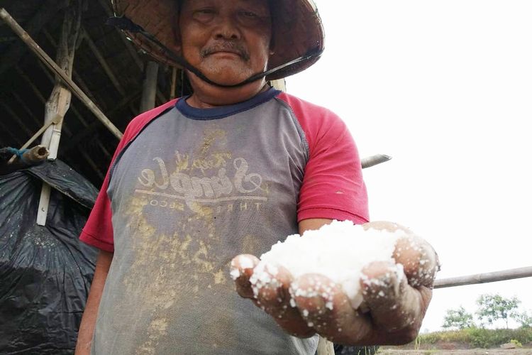 Samiun (45), petani garam asal Desa Luwunggesik, Kecamatan Kerangkeng, Kabupaten Indramayu, saat menunjukan garam kualitas dua (Kw 2). Saat ini harga garam kualitas dua di Indramayu Rp 450 dan kualitas pertama Rp 500 perkilogramnya. Adanya kebijakan impor garam oleh pemerintah petani garam Indramayu diharapkan ada kenaikan harga. 