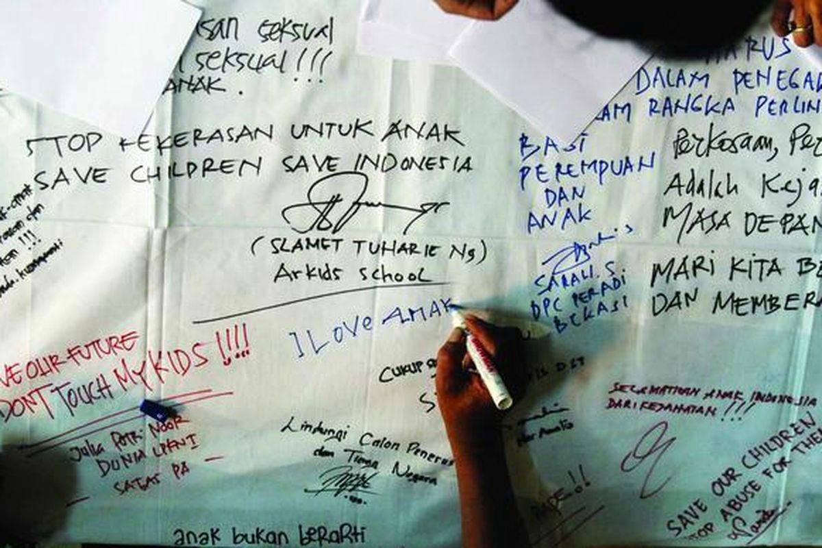 Para simpatisan menulis pernyataan dukungan pada  bentangan kain dalam Malam Solidaritas untuk Anak Korban Kejahatan Seksual di Gedung Lembaga Perlindungan Saksi dan Korban (LPSK), Jakarta, Rabu (9/1). Acara ini digelar sebagai dukungan moral kepada korban dan keluarga korban kejahatan terhadap anak. 
