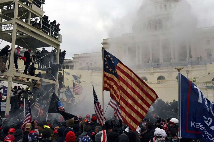 Pendukung Presiden Amerika Serikat Donald Trump melakukan protes di depan Gedung US Capitol di Washington, Amerika Serikat, Rabu (6/1/2021). Hari pengesahan kemenangan presiden terpilih Joe Biden oleh Kongres di Gedung Capitol diwarnai penyerbuan massa pendukung Donald Trump dalam upaya menggagalkan anggota parlemen dari tugas konstitusional mereka.