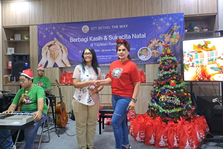 Ketua Panitia Natal STTB The Way, Eli Brigita Purba, secara simbolik memberikan bantuan kepada Yayasan Pendidikan Dwituna Rawinala. 