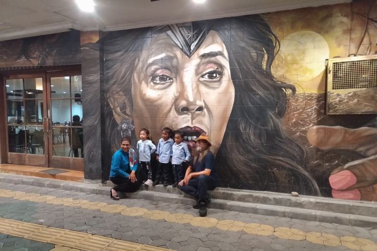 Susi berfoto bersama cucu-cucunya dan seniman mural Sardono W. Kusumo di depan mural dirinya di Jalan Slamet Riyadi, Solo