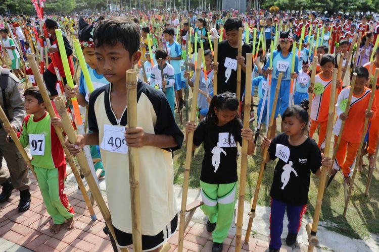 Peserta Festival Permainan Anak Banyuwangi 2016 bersiap melakukan parade dengan berjalan menggunakan egrang bambu. Akhir pekan ini (22/7/2017), Banyuwangi kembali menggelar festival permainan tradisional yang melibatkan lebih dari 5 ribu anak dari 25 kecamatan.
