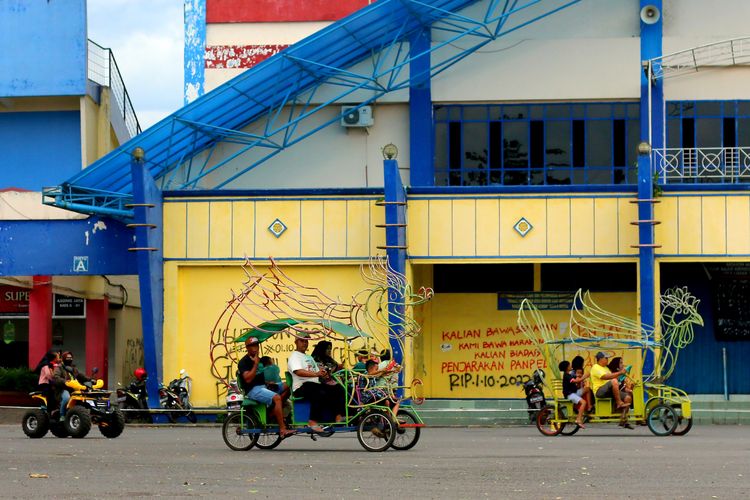 Suasana halaman stadion pasca 3 bulan terjadinya Tragedi Kanjuruhan, tampak sejumlah keluarga menikmati libur dengan berkeliling menggunakan sewaan becak hias di Stadion Kanjuruhan Kepanjen, Kabupaten Malang, Minggu (1/1/2023) siang. 