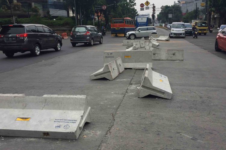 Puluhan warga dibantu pengendara yang melintas membongkar pembatas jalan di Simpang Duren Tiga, Kelurahan Duren Tiga, Kecamatan Pancoran, Jakarta Selatan, Sabtu (19/5/2018). Adapun pembatas jalan tersebut dipasang sebagai bagian uji coba penutupan simpang untuk memperlancar arus lalu lintas pasca-beroperasinya lintas bawah atau underpassMampang-Kuningan.