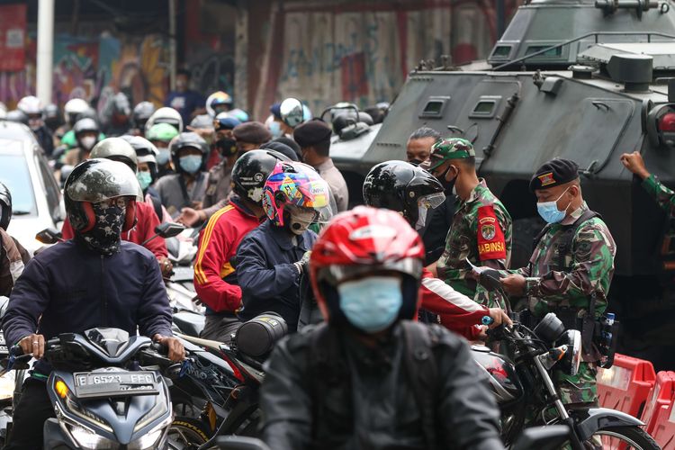 Anggota TNI dan Polri melakukan penyekatan kendaraan saat PPKM Darurat di Jalan Raya Lenteng Agung, Jakarta Selatan, Senin (5/7/2021). Penyekatan ini mengakibatkan kemacetan parah di ruas Jalan Raya Lenteng Agung.