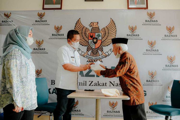 Aep bersama kakak kandungnya Lia dan orang tuanya menyerahkan zakat mal tahun 2022 kepada Badan Zakat Nasional (Baznas) Kabupaten Karawang, Rabu (20/4/2022).