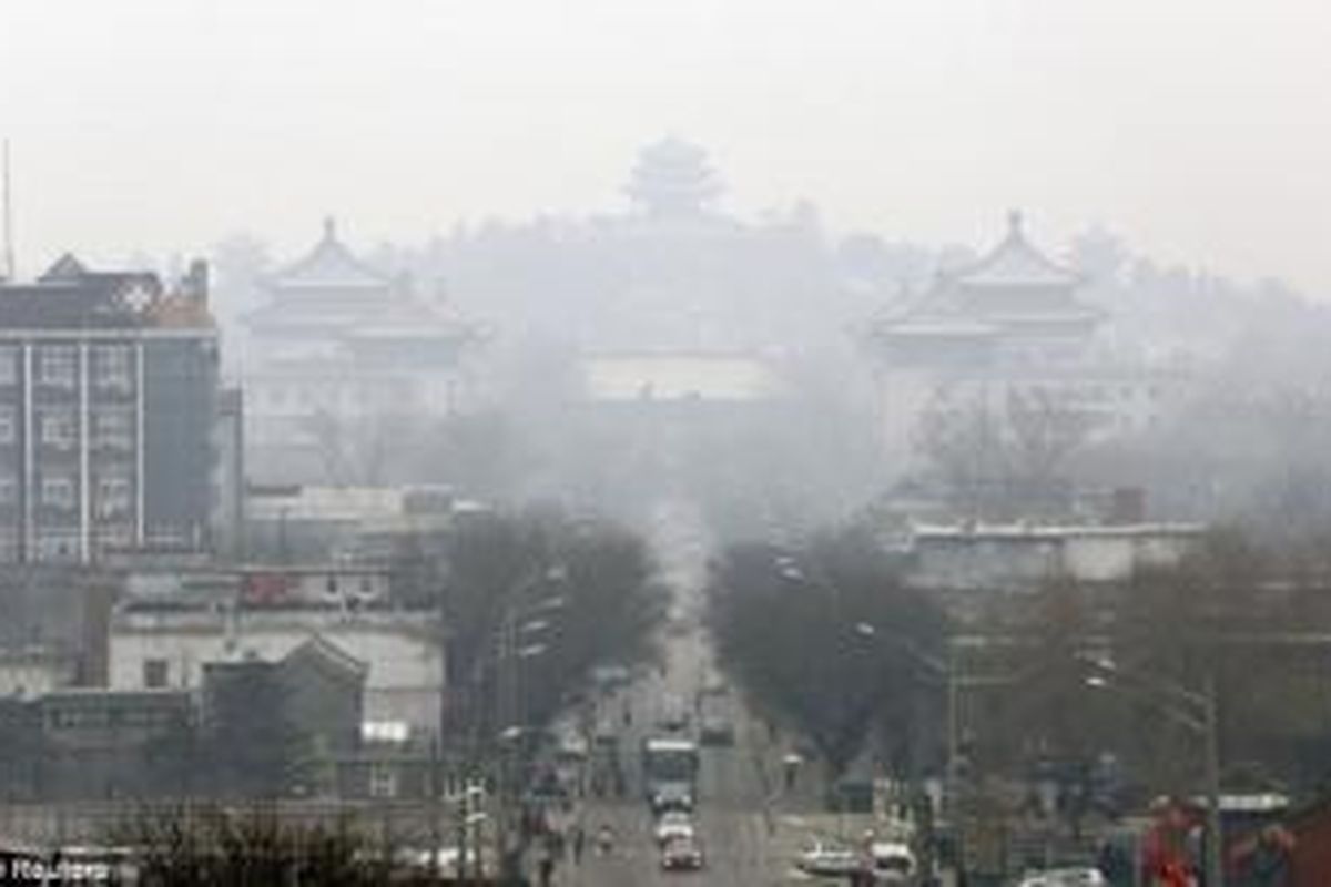 Sejumlah kendaraan terlihat di jalan dekat Taman Jingshan di tengah kabut tebal di pusat kota Beijing